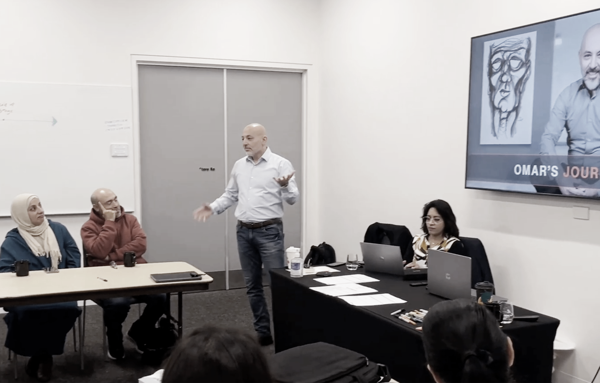 Speaker leading a founder session in a training room.